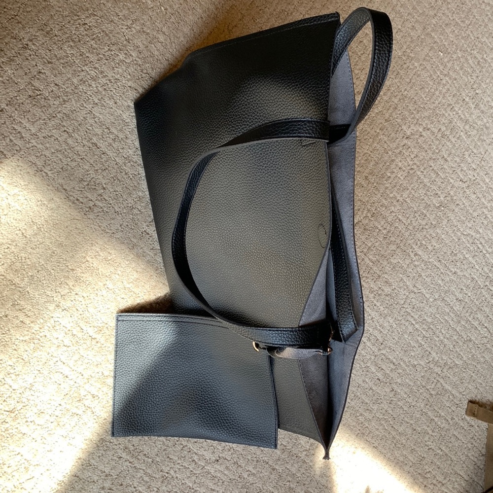 Brand new black vinyl, looks like leather with a small zippered attached bag.